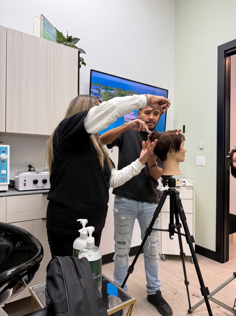 Hands-on barber cutting demonstration during a training session